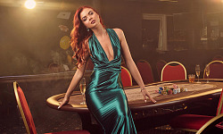 sexy redheaded female long blue satin dress is posing sitting poker table looking camera luxury casino passion cards chips alcohol win gambling it is as female entertai